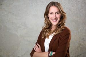 Bewerbungsbild von einer Frau vor grauer Wand mit struktur.
