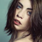 Portrait von einer frau mit blauen Augen und dunklen haaren im Fotostudio.