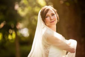Wunderschöne Braut in weißem Hochzeitskleid in der Natur.