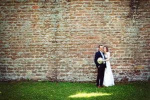 Verliebtes Hochzeitspaar auf großer Wiese.