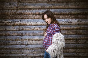 Babybauchshooting im Freien von einer Frau mit noch kleinem Babybauch.
