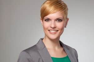 starkes Bewerbungsbild mit Frau mit kurzen roten Haaren